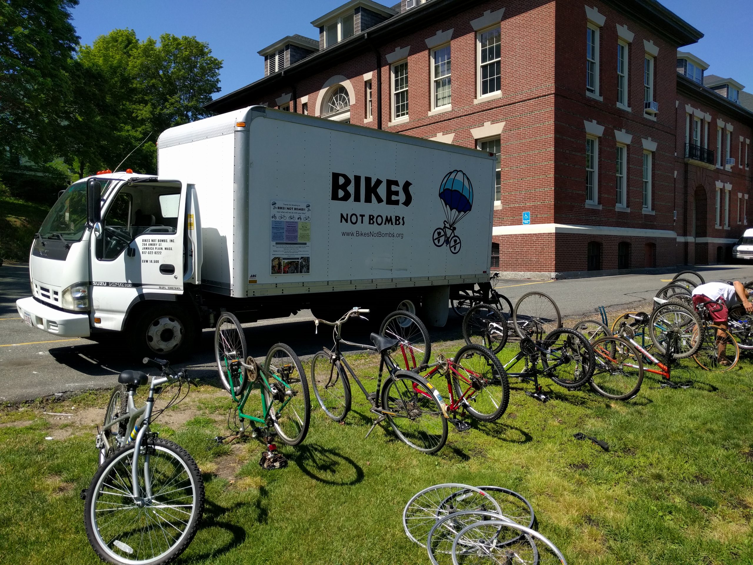 Used bicycles wait to be loaded onto a truck that says Bikes Not Bombs