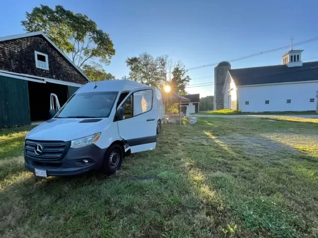 A white cargo van shown at a farm