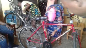 two people working on bicycles